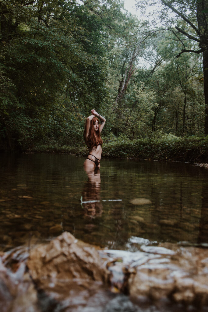 Woman in the water with lingerie with arms above her head